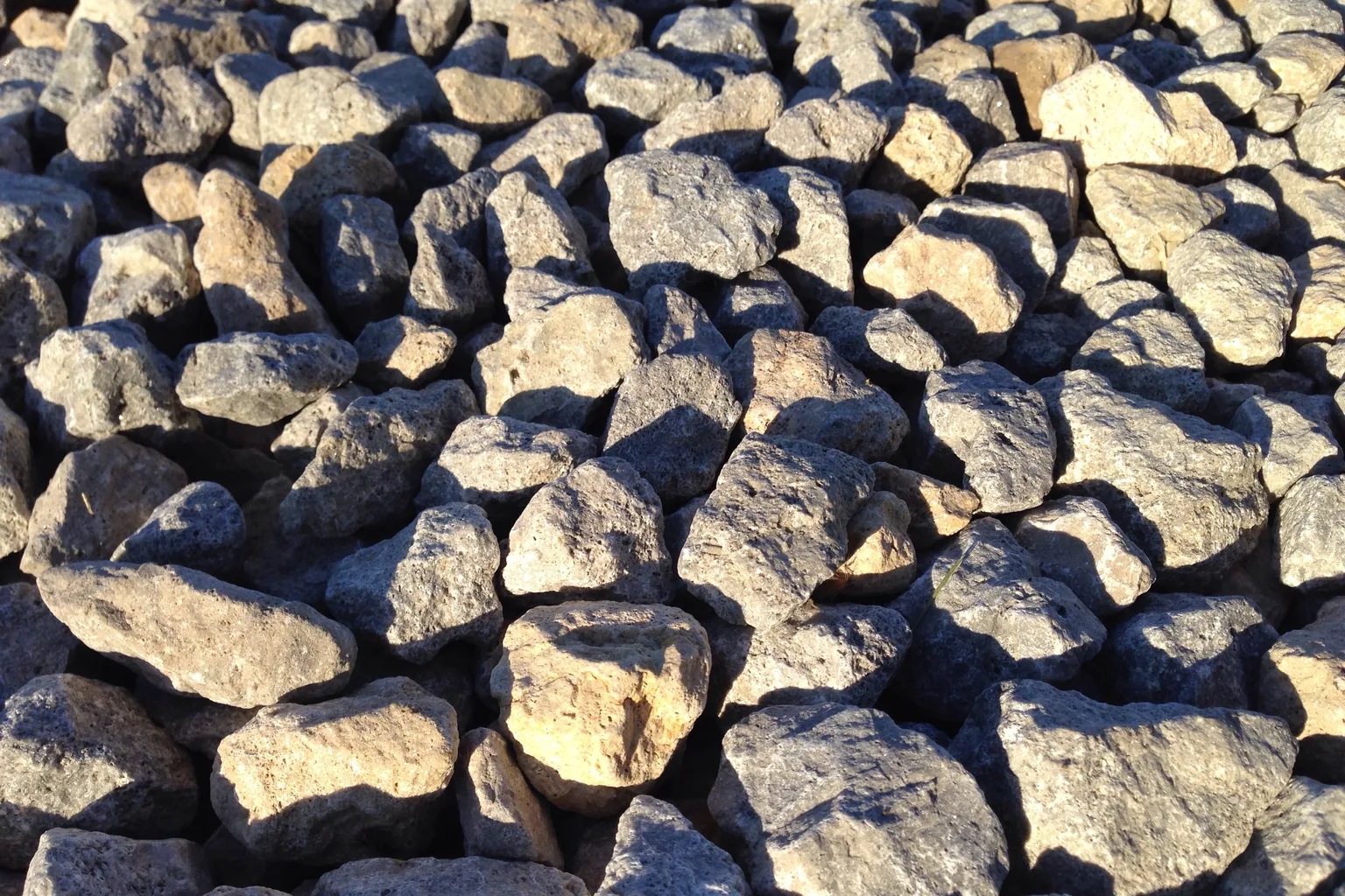 Gravel driveway leading up to a home, compared against asphalt paving costs for 2026