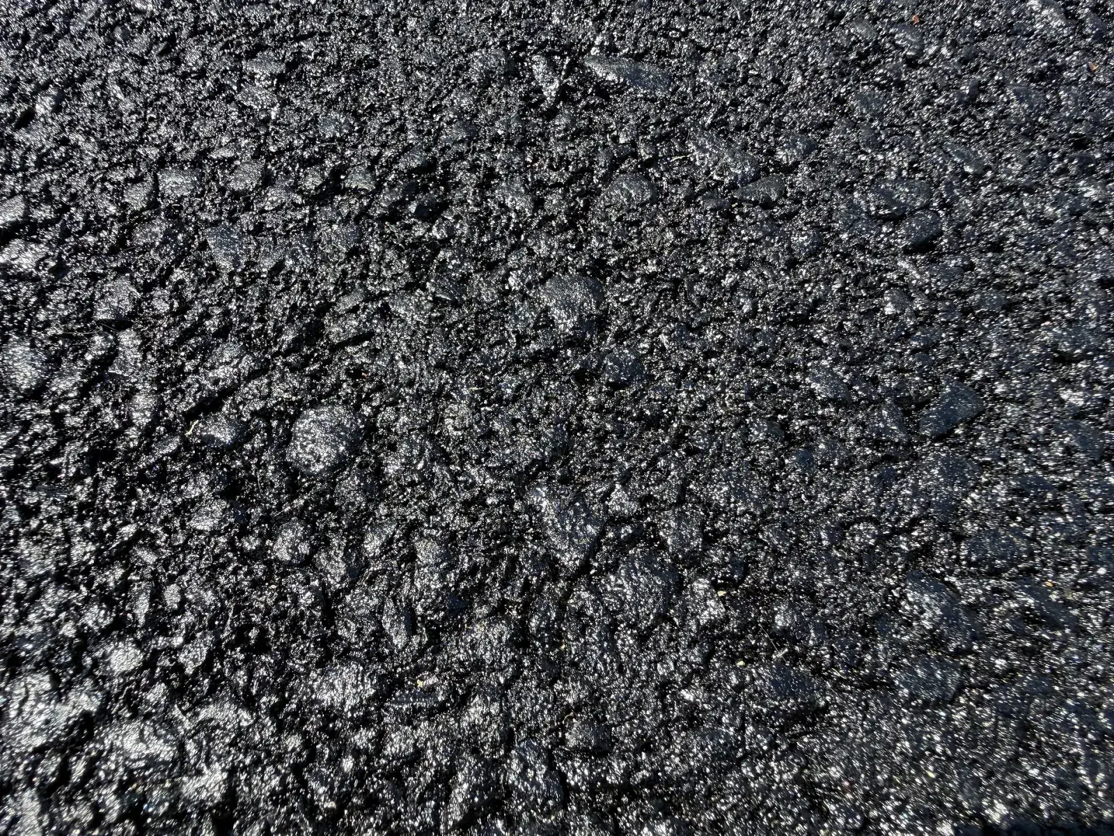 Close-up of freshly laid hot mix asphalt on a newly paved residential driveway in New Jersey, April 2026